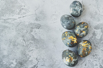 Banner. Easter eggs are gray and gold on a gray marble background. Minimal concept. View from above. Card with copy space for text