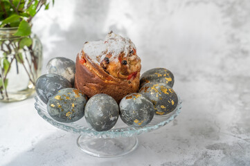 Easter kulich, bunnies and eggs with golden pattern. A plate with kraffin, Easter eggs and bunnies. The concept of home comfort in the bright holiday of Easter.