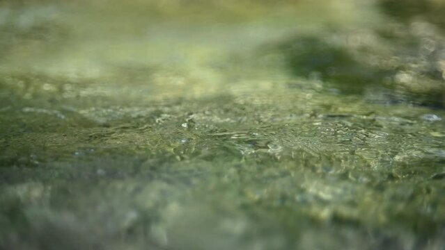 Flowing water from a mountain stream in the evening (abstract, slow motion)