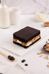 homemade cake with cream nuts and chocolate on the table with milk