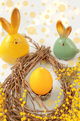 Candle in the form of an Easter egg in a nest. Easter decoration on a wooden table