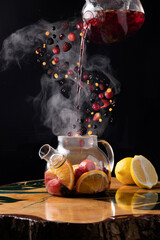 natural fruit tea with berries is poured into a teapot, the berries levitate and steam comes