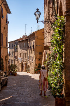 A person walking on a scenic alley in downtown Volterra