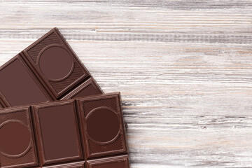 Black chocolate on a gray background top view, copy space