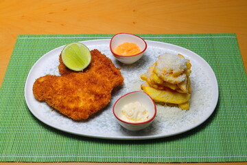 Chicken schnitzel with salad and pasta on the wooden background.