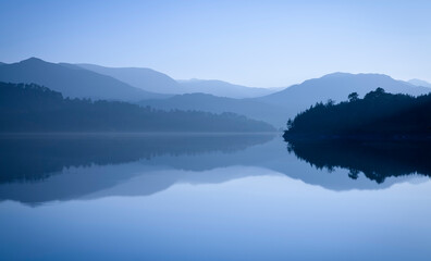 Mountains reflected in blue lake. Glen Affric, Scotland, UK