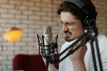 A close view of a musician, emotionally engaged in recording a soulful melody in his modern home...