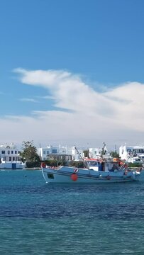 Fisherman boat arrive at pier in Milos island, Greece on sunny day