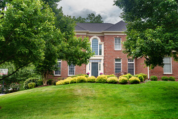 Residential two-story detached house with green lawn in front