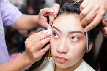 Fototapeta premium Photo of young girl being made up, painted eyes. Concept of people and beauty.