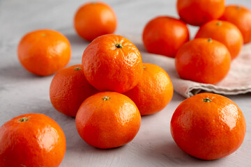 Organic Raw Mandarin Oranges on a gray background, side view.