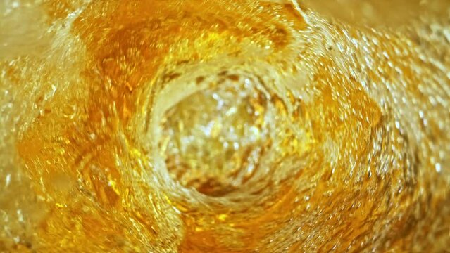 Super Slow Motion Shot of Fresh Beer Whirling inside Glass Bottle at 1000fps.