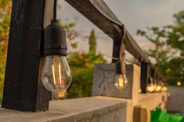 Light bulb hanging on the hand rail cafe restaurant. The photo is suitable to use for decorative background and cafe content media.