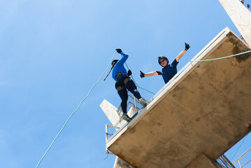 Rappelist preparing to descend the rope from a great height. Healthy and dangerous sport.