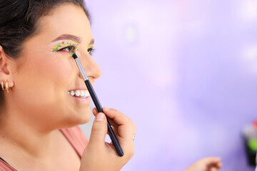 Close-up of a smiling Latina woman who is happy while applying makeup