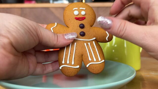gingerbread man Gift for Christmas delicious cookies take out from packaging dance beautiful toy delicacy female hands with shiny Christmas manicure Present yami. symbol of winter New Year