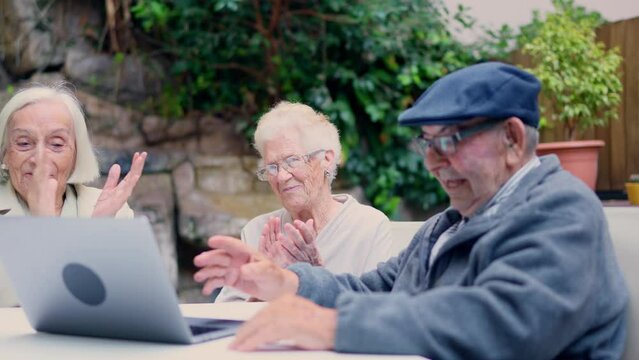 Senior people applauding during a video call in a geriatric