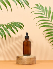 Glass bottle for cosmetics, oils with a pipette on a beige background