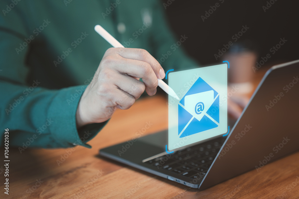 Poster Male hand using a computer laptop typing on keyboard and surfing the internet on office table with email icon. Concept of Email marketing, send e-mail or news letter, online working internet network.