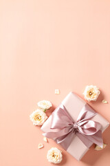 Gift box with pink ribbon bow, rose buds on peach color background. Happy Valentines vertical banner design