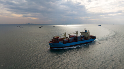 logistic cargo container ship sailing in sea to import export goods and distributing products to dealer and consumers across worldwide, aerial front view