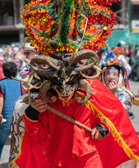 People with devil masks dancing at the Diablada Pillarena, a traditional festival of Ecuador