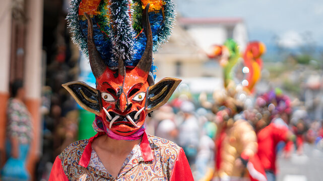 People with devil masks dancing at the Diablada Pillarena, a traditional festival of Ecuador