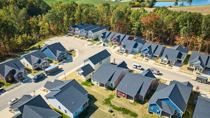 Aerial Suburban Homes with Seasonal Trees Near Water