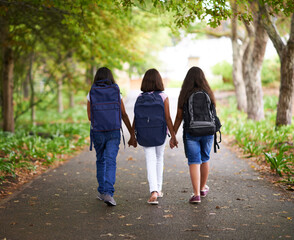 Woman, friends and holding hands with backpack in park to school for unity, teamwork or community....