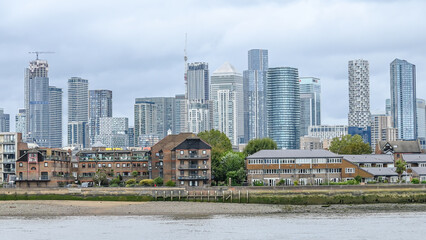 Fototapeta premium London, UK, 24 September 2023: The iconic skyline of Canary Wharf, business district located near the Isle of Dogs, as seen from the Cutty Sark clipper ship in Greenwich, London, England, UK 
