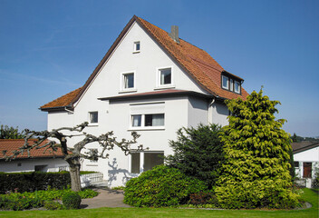 Fototapeta na wymiar generic old family house in Germany with white facade and garden in front