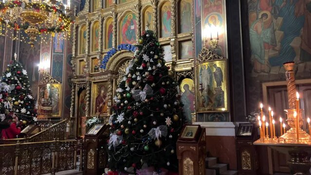 Orthodox Church inside Christmas Eve decorations Christmas Tree candles beautiful icons birth of Jesus congratulations ringing bells. celebration 