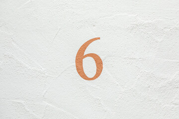 house number 6 at a white painted wall
