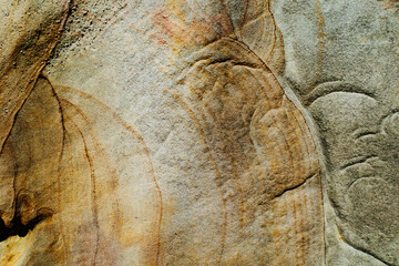 The flat surface of a rough sandstone wall with interesting patterns and colors