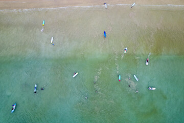 Aerial view of surfers waiting for waves off a tropical beach (Memories Beach, Khao Lak, Thailand)