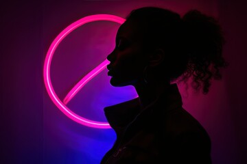 Side view of unrecognizable trendy black model silhouette standing near neon female symbol glowing with purple light