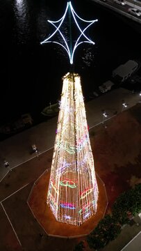 Imagem a&eacute;rea de drone da cidade de Guarapari a noite, praia do morro e prainha de muqui&ccedil;aba iluminadas. Decora&ccedil;&atilde;o de natal e festas de final de ano.