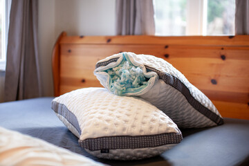 A set of two king size Gel Memory Foam pillows sit on a bed with the zipper open exposing the foam...