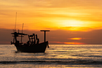 Silhouette of boat against colourful sky