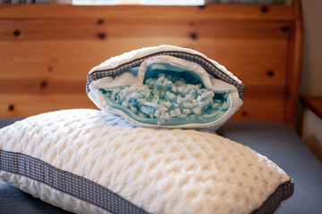 A set of two king size Gel Memory Foam pillows sit on a bed with the zipper open exposing the foam...