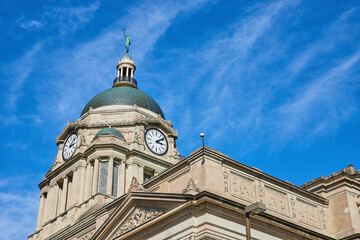 Fototapeta na wymiar Classical Courthouse Clock Tower Against Blue Sky