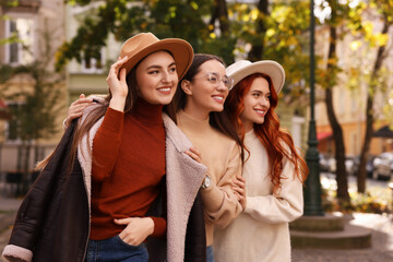 Portrait of happy friends posing outdoors on autumn day