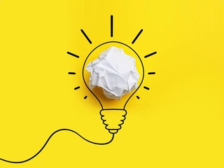Idea. Illustration of light bulb around crumpled paper ball on yellow background, top view