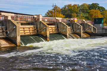 Autumnal Trees and Flowing Dam Water at Huron River, Eye-Level View