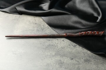 Magic wand and dark cloth on light grey table