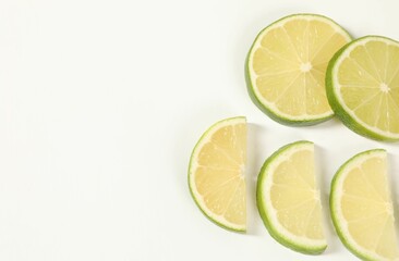 Lime pieces on white background, above view. Space for text