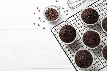 Tasty chocolate muffins on white wooden table, flat lay. Space for text