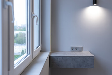 Modern apartment design. Window, floating bedside table, wall lighting and radiator
