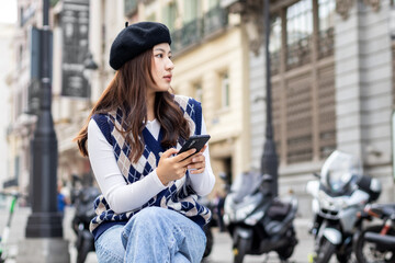 Young asian woman using smartphone in the city