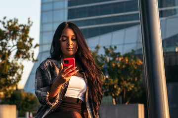 Close up of a brunette young latin woman using smartphone